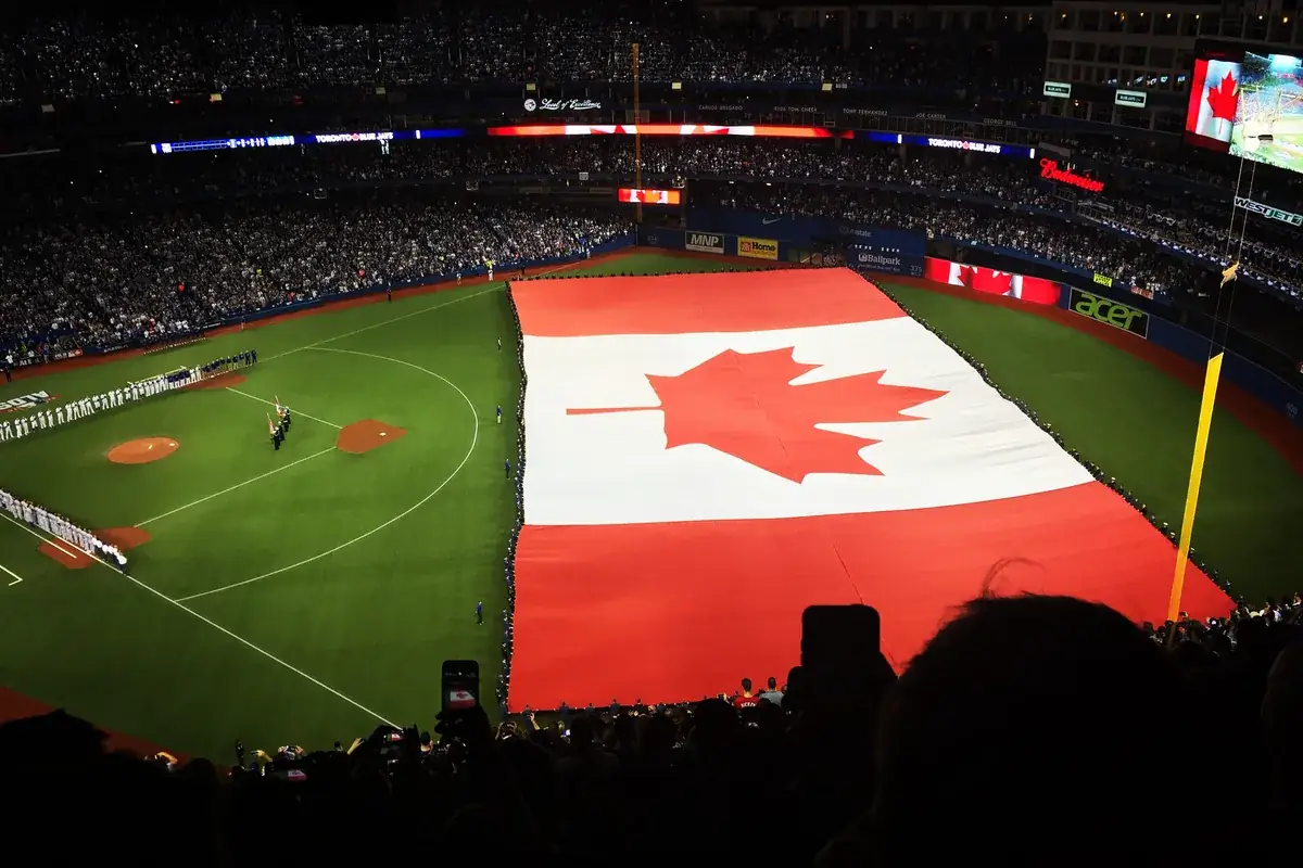 Giant Canadian flag spread across the field at a Toronto Blue Jays game